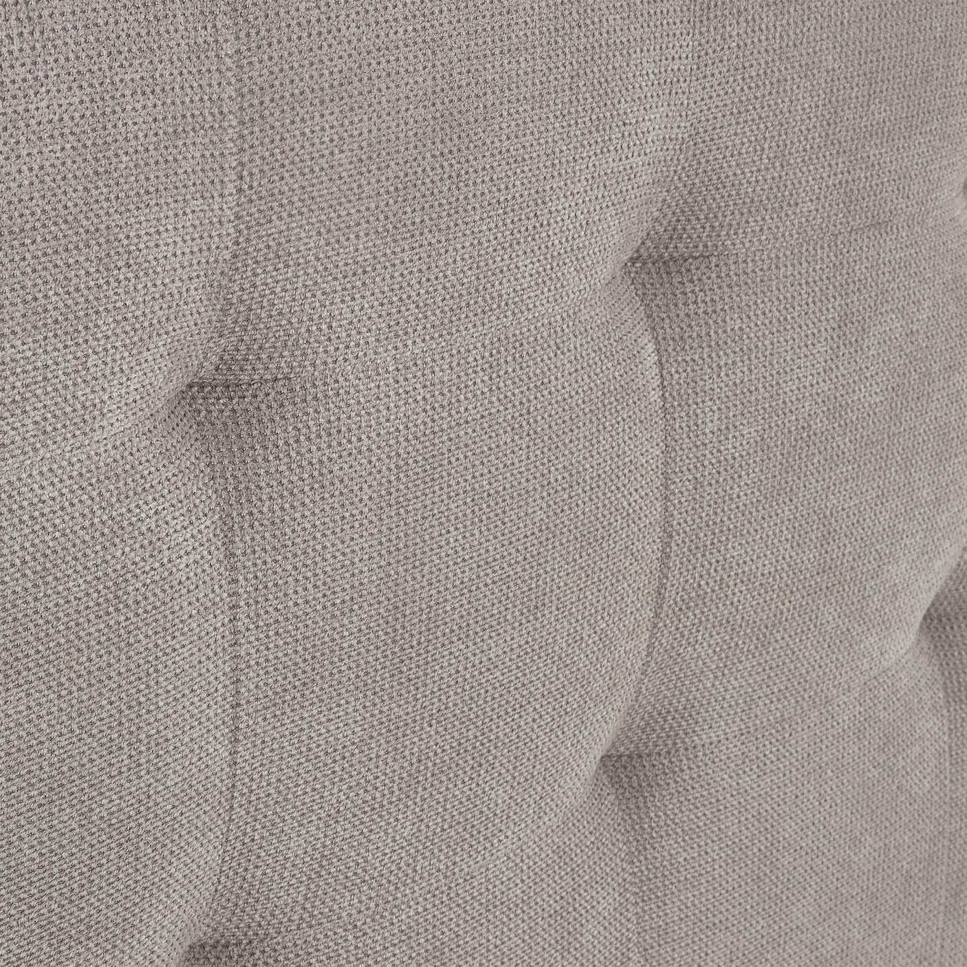 Close up of grey upholstered bed fabric with button tufted headboard detail