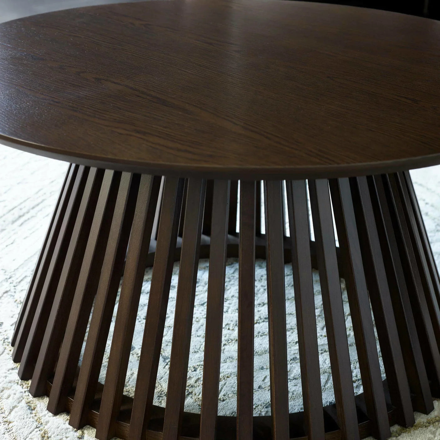 Dark wood coffee table with slatted base on textured rug
