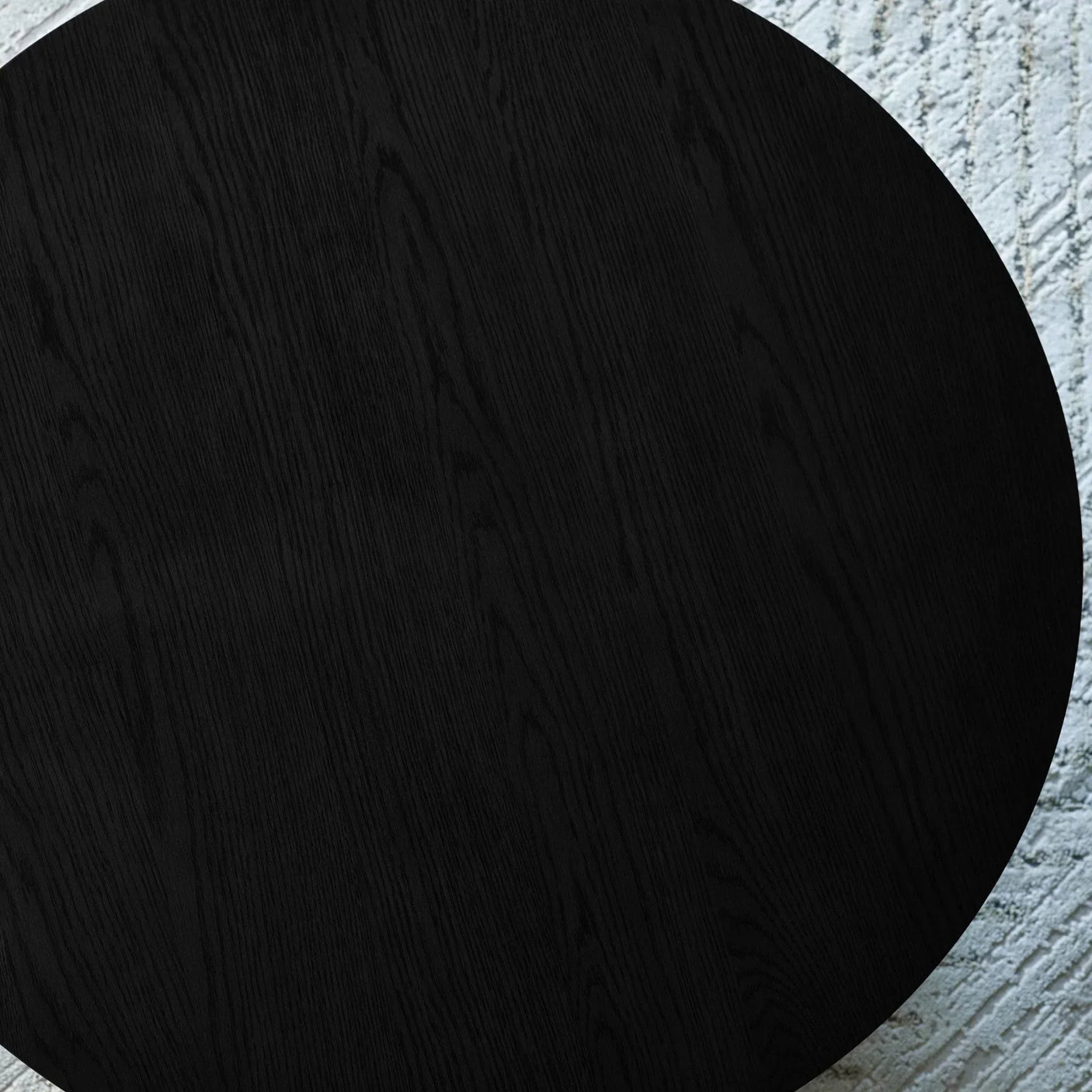 Black wooden dining table top with natural grain detail on light textured rug