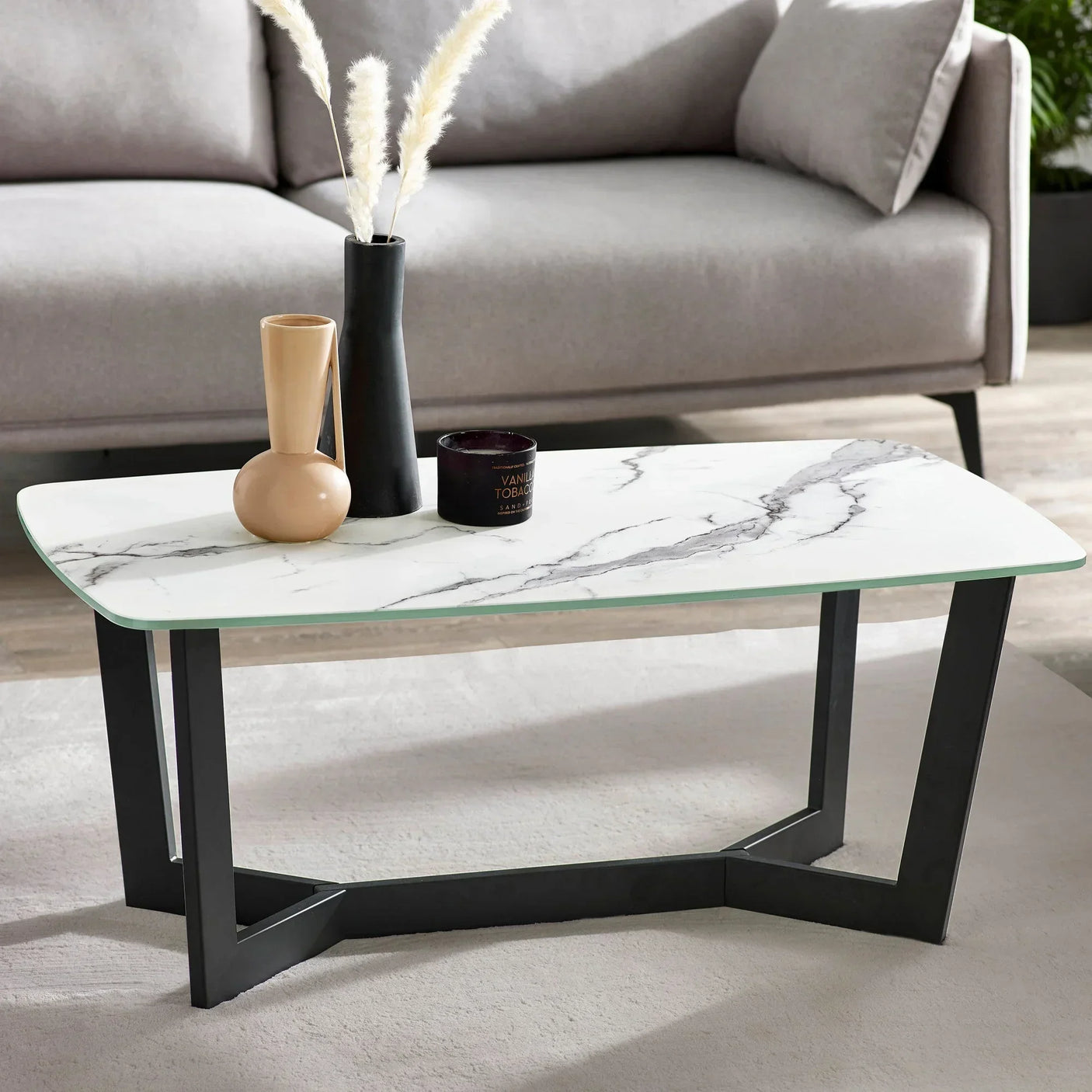 Marble effect coffee table with black metal legs beside grey sofa
