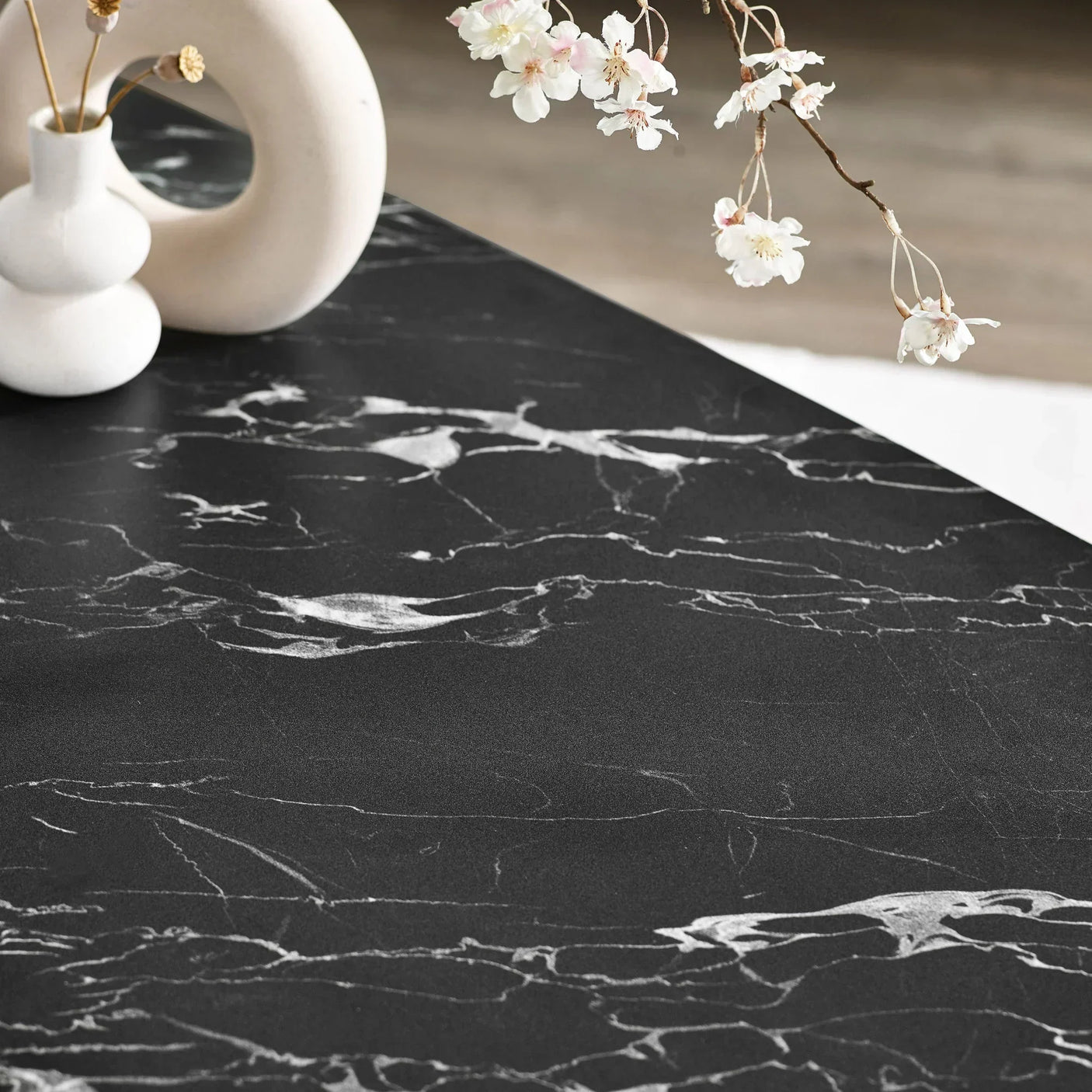 Black marble dining table top with white veining and modern ceramic vase decor