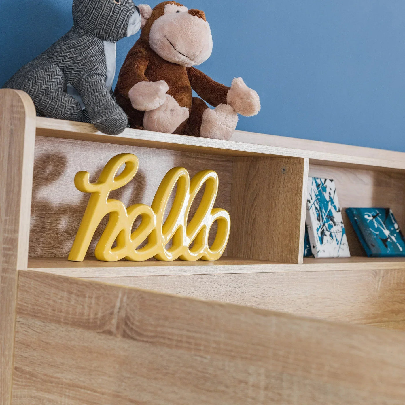 Oak-effect shelving unit with toys and yellow decorative hello sign