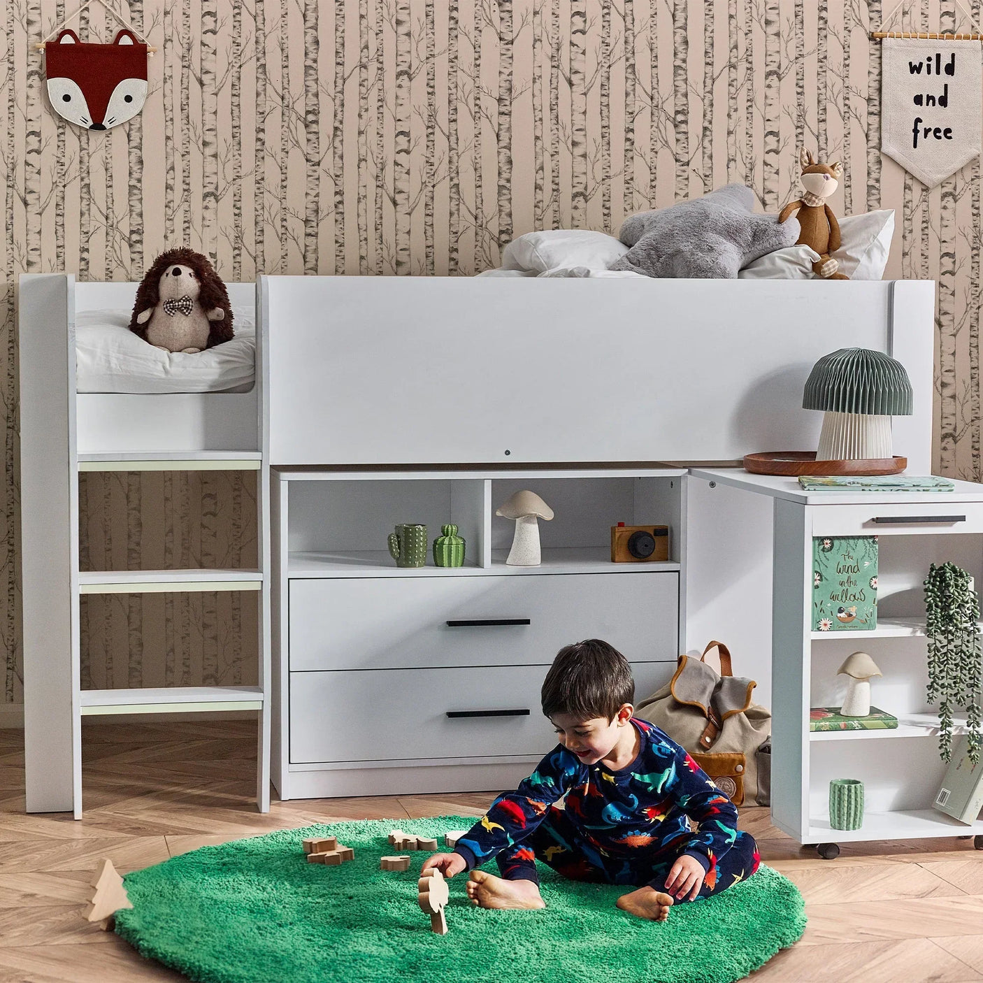 White midsleeper bed with built-in storage, ladder, and child playing on green rug