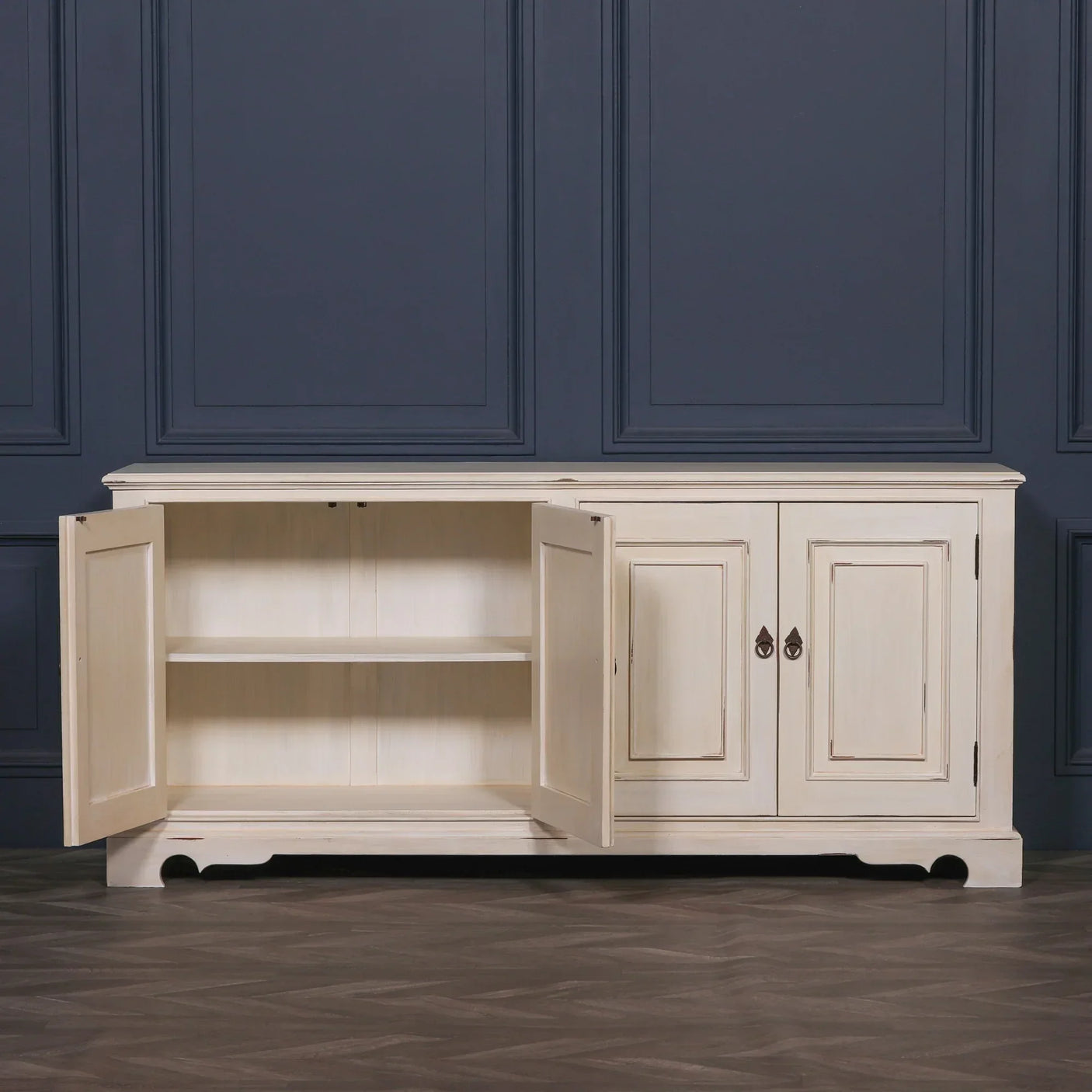 Cream wooden sideboard with double doors open showing interior shelf, set against blue wall