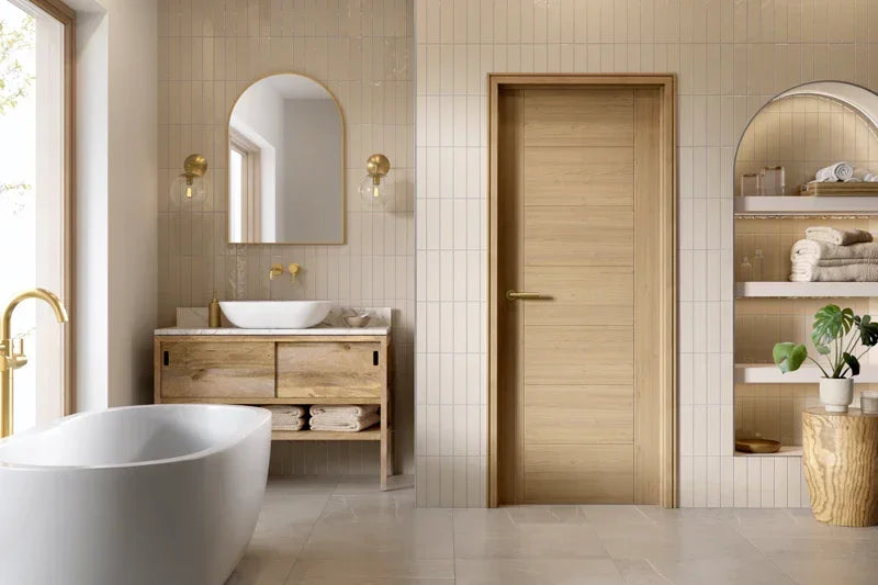 Oak internal door with modern handle in a beige tiled bathroom with vanity and bathtub