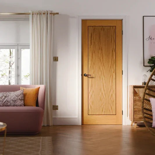 oak interior door with panel in modern living room, pink sofa and wooden floor