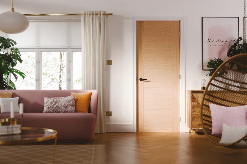 Oak interior door with 5 panels in modern living room, pink sofa and natural wood accents