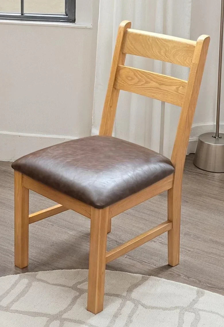 Oscar low chair with light wood frame and brown PU seat on wood floor