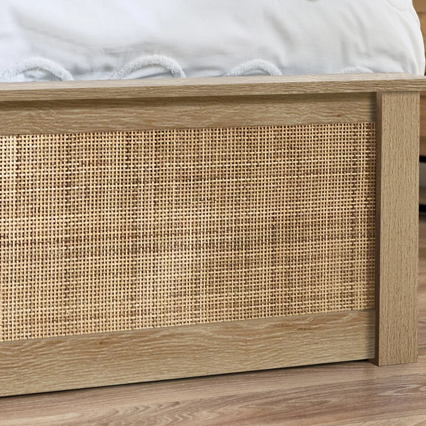 Closeup of oak rattan double ottoman bed footboard showing woven panel and wood grain