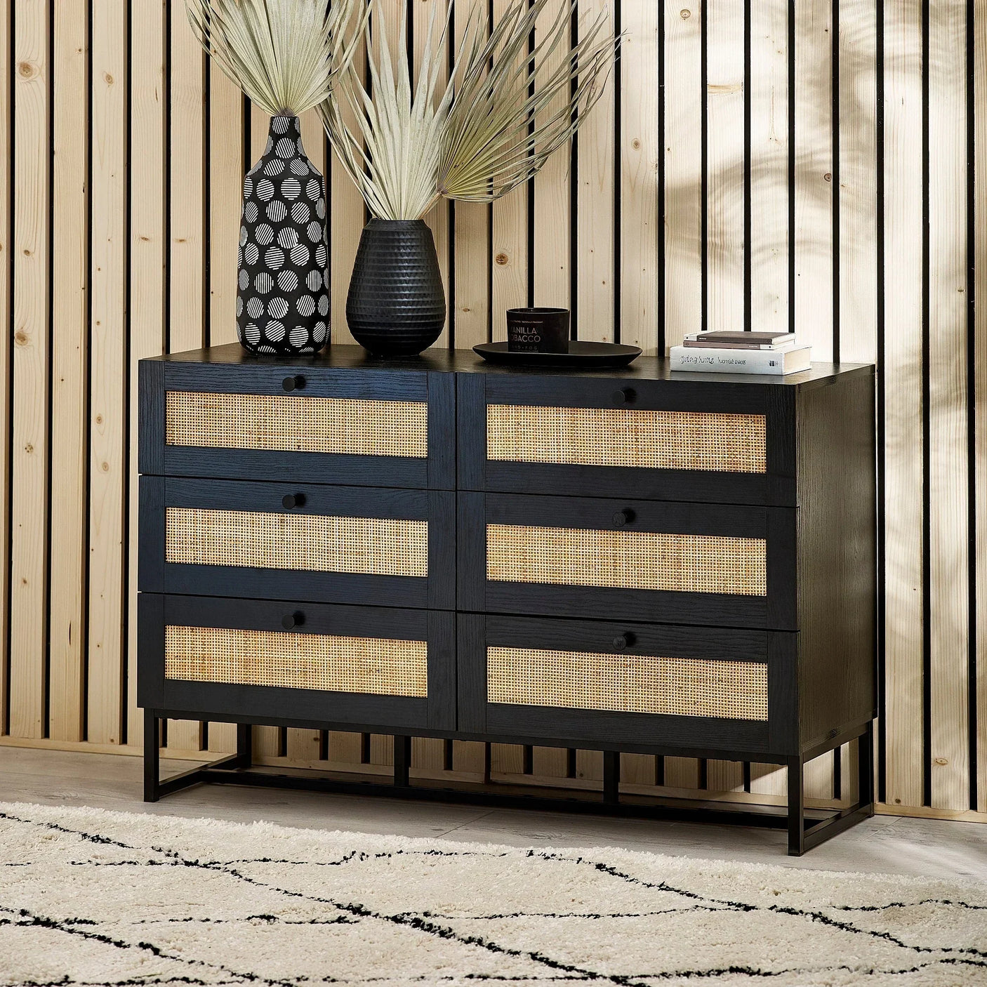 Black 6 drawer chest with rattan fronts, styled with vases, books and decor in modern room