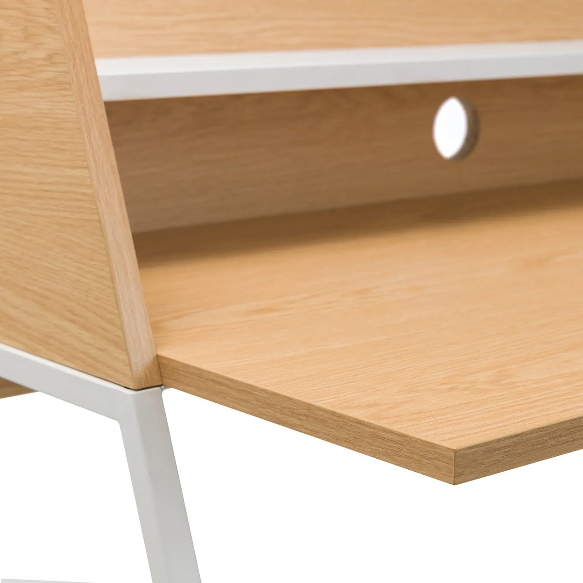 Oak wood desk surface with white metal frame and cable management hole detail