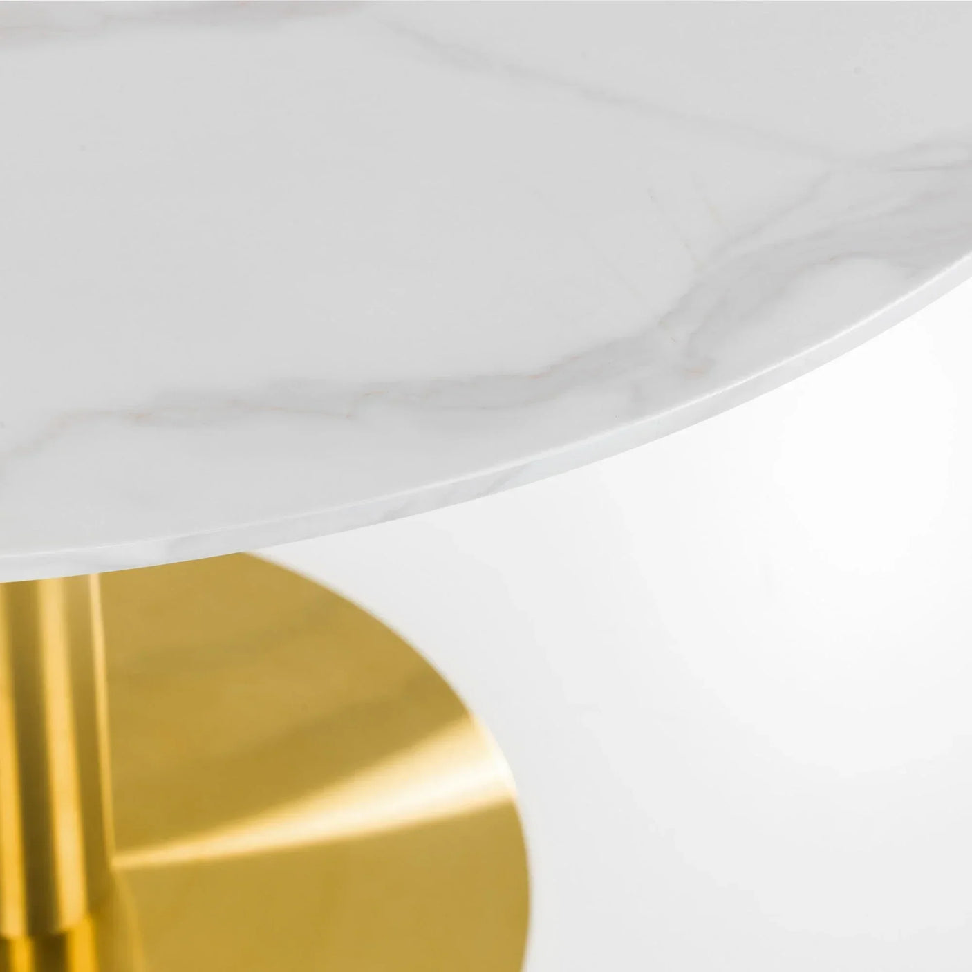 Round marble dining table close-up with white top and gold pedestal base