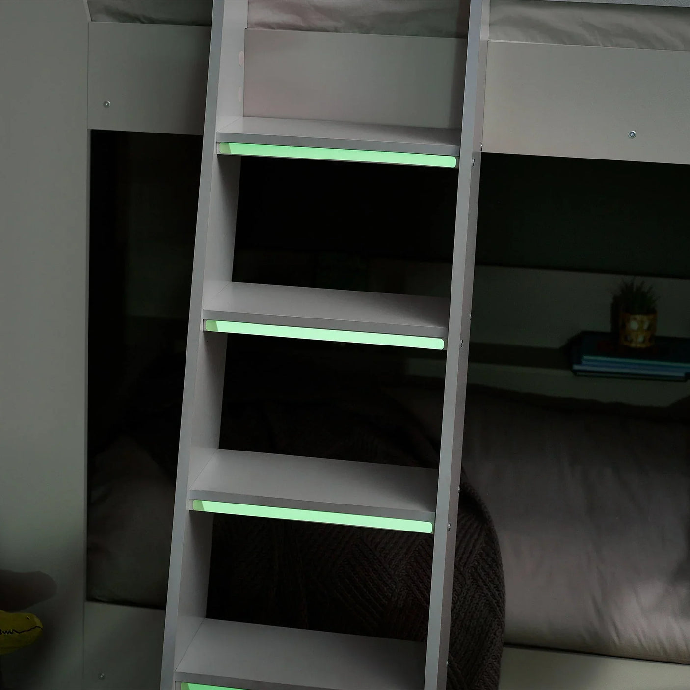 White bunk bed ladder with glow-in-the-dark steps and lower bunk background