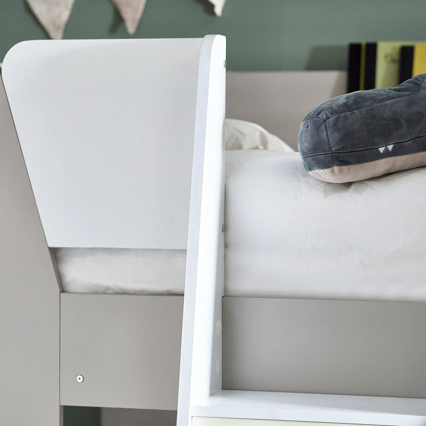 Closeup of taupe and white bunk bed with visible ladder and stuffed toy on mattress