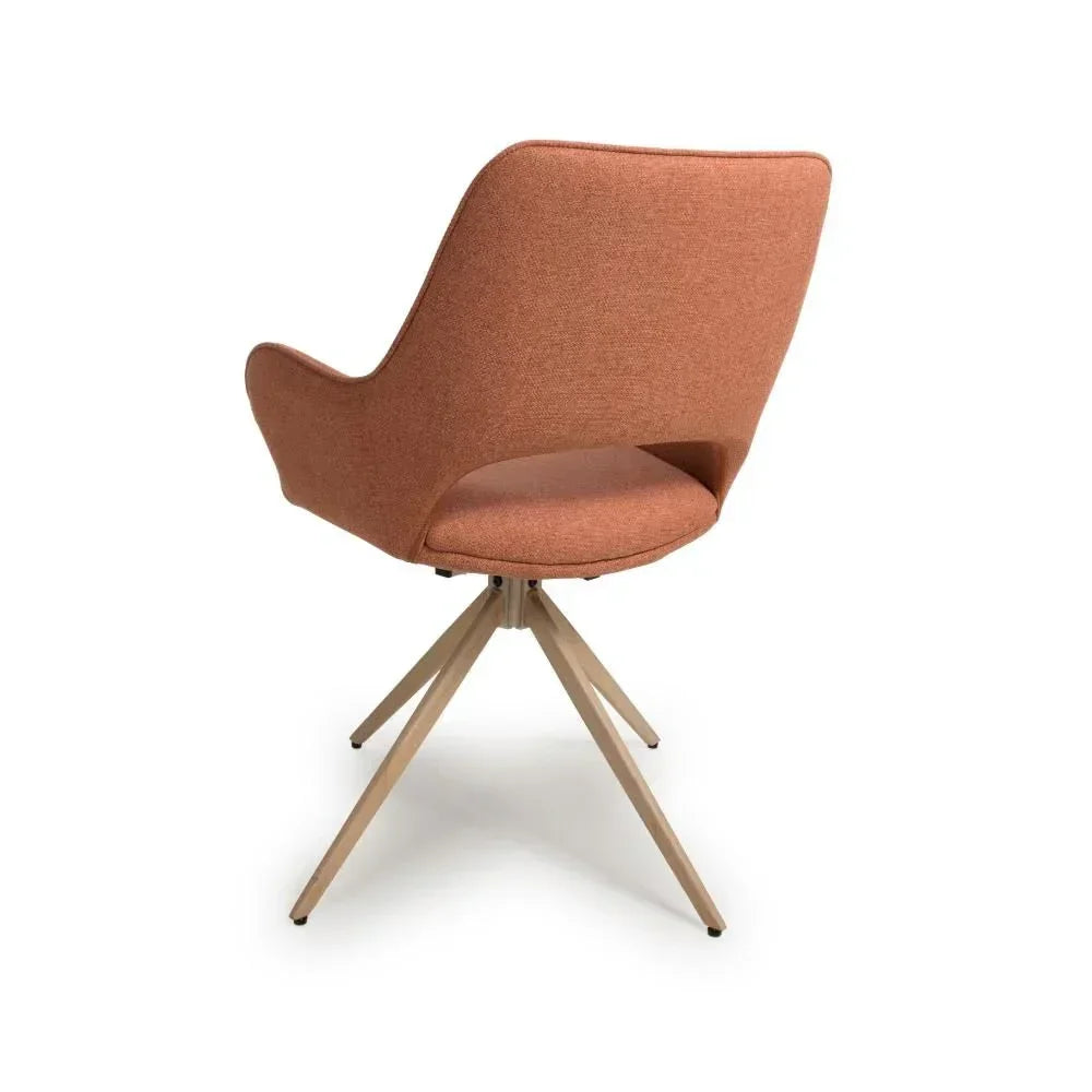 Rust fabric swivel accent chair with curved back and wooden legs, rear angle view