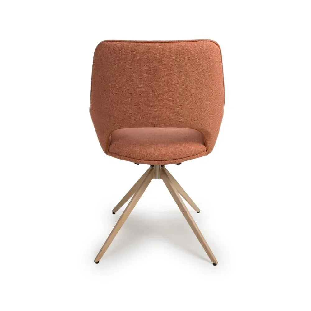 Rust fabric dining chair with curved backrest and light wooden angled legs, rear view