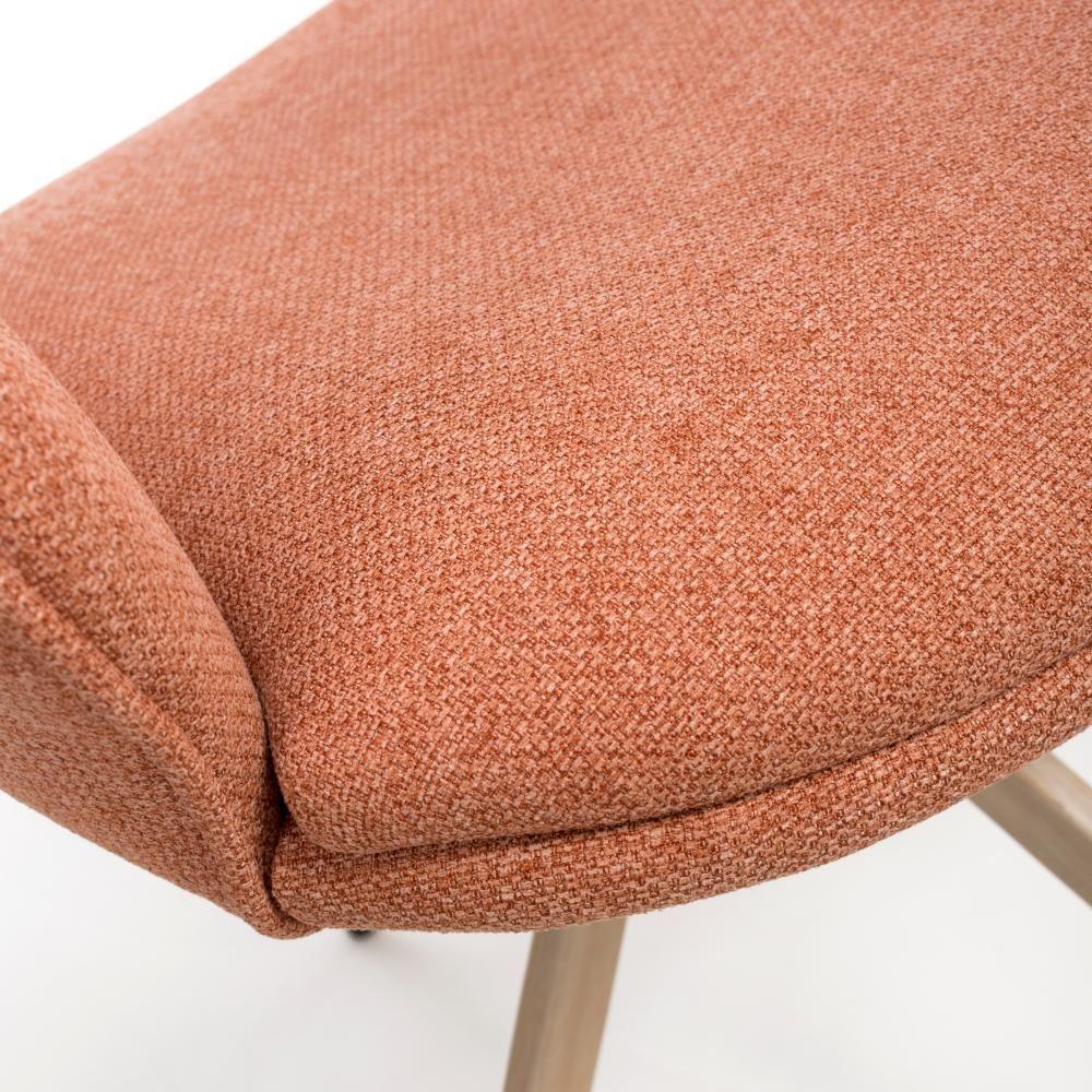 Closeup of textured orange fabric dining chair seat with light wood legs