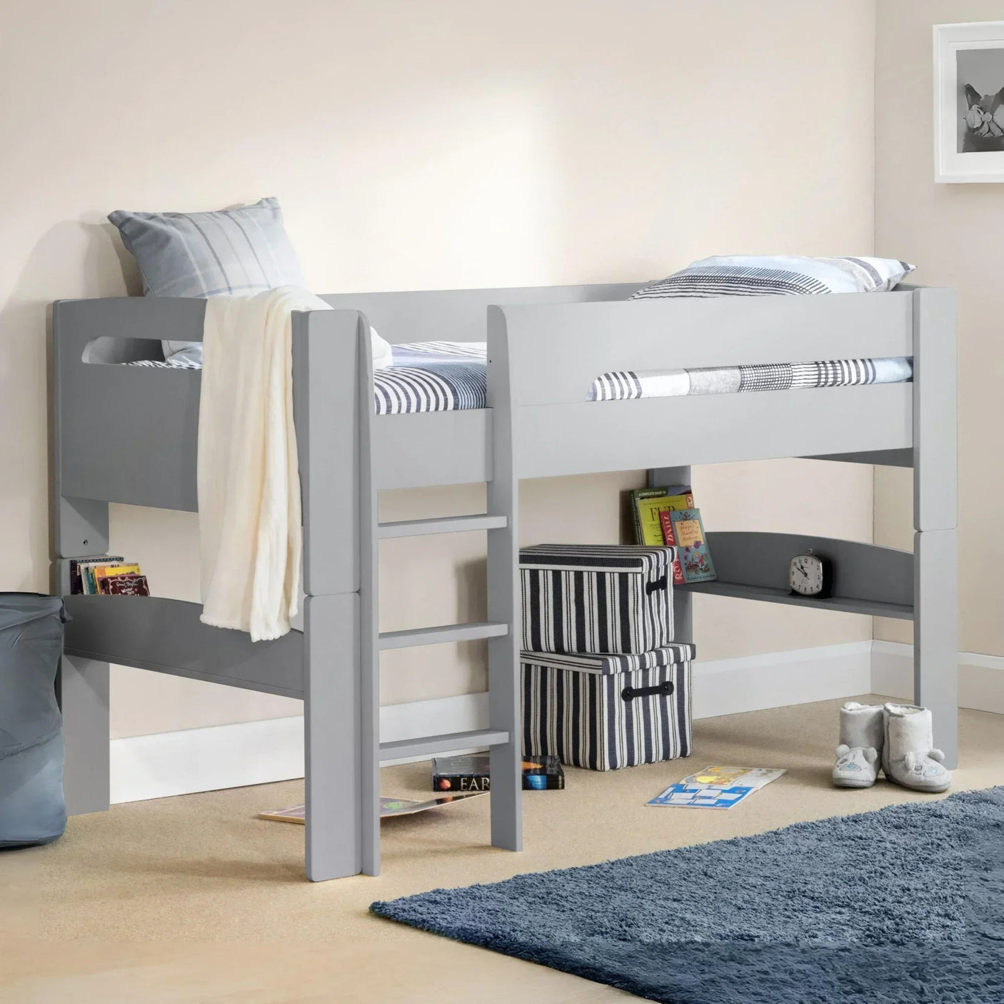 Grey wooden mid sleeper bed with ladder, striped bedding and storage space underneath