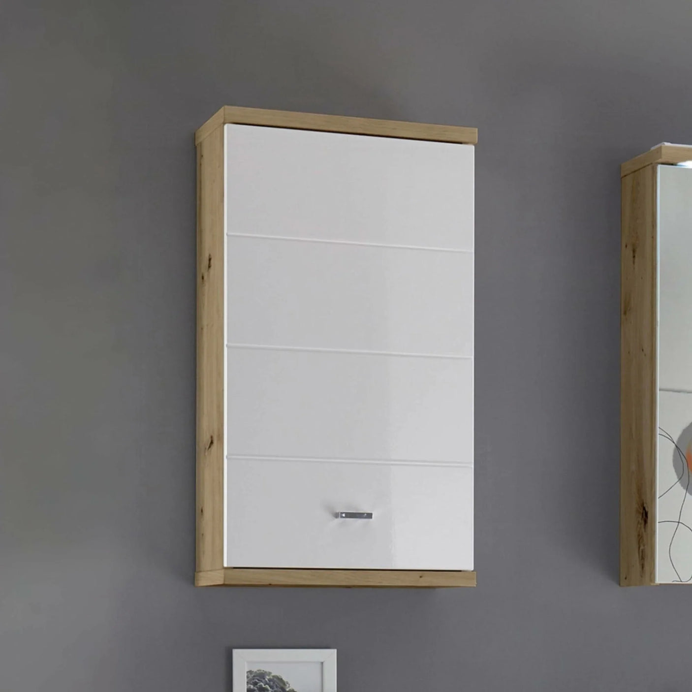 White and oak wood wall cabinet with single door and chrome handle mounted on grey wall