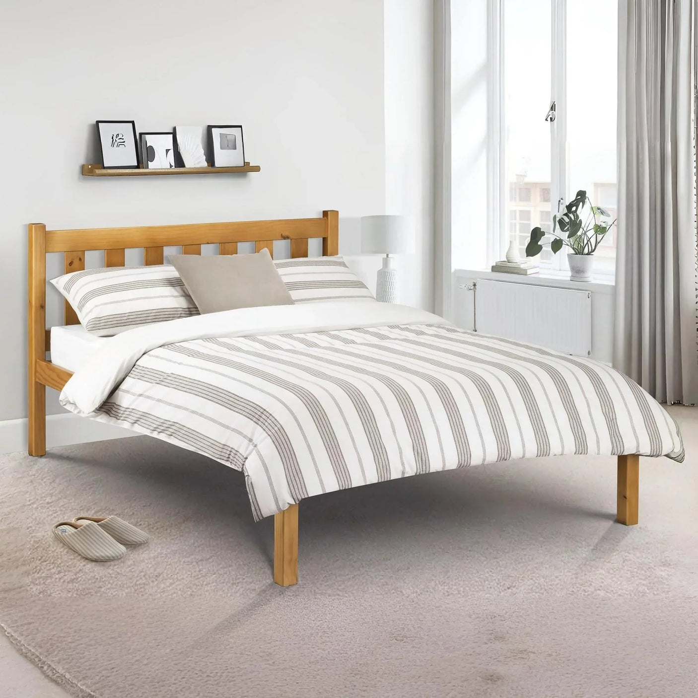 Wooden bed frame with striped bedding in bright bedroom with window and minimalist decor