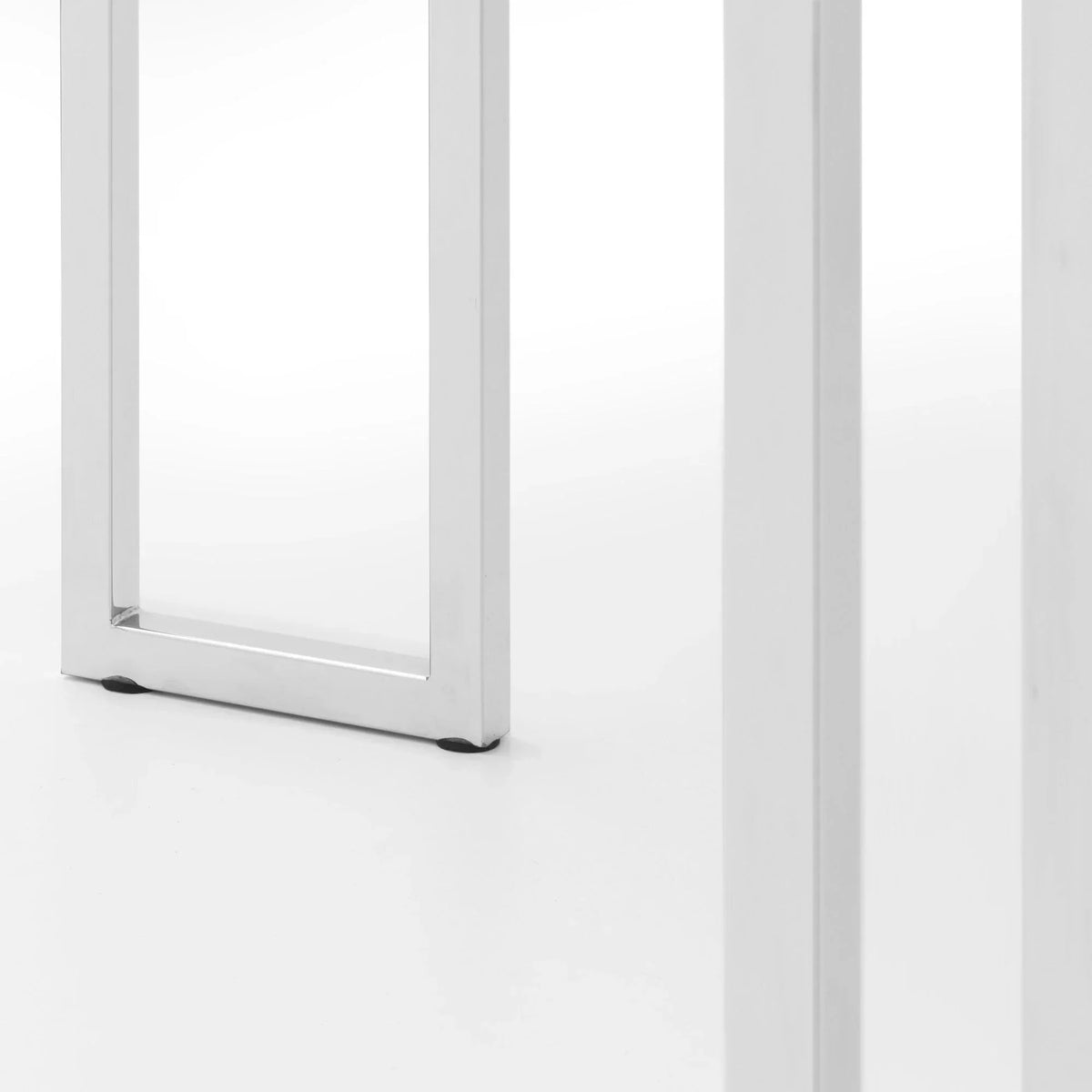 Closeup of chrome metal dining table legs on white floor