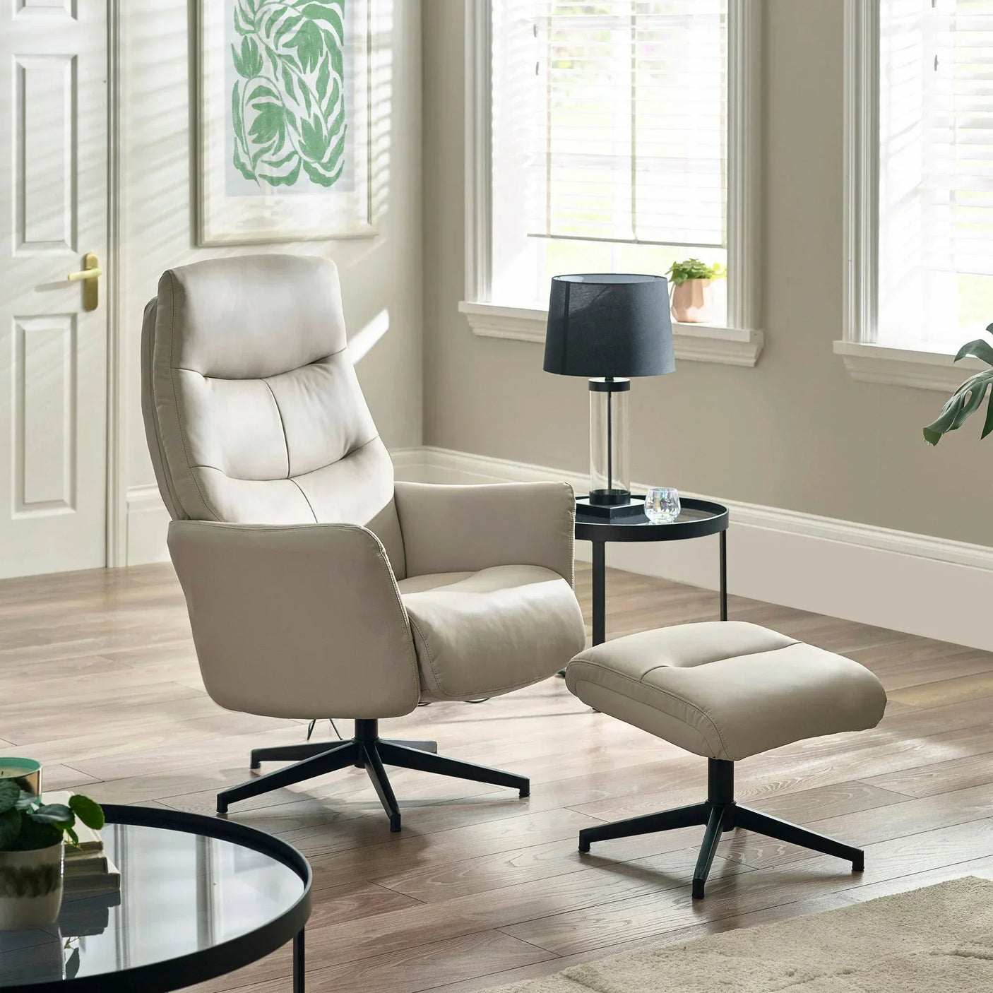 Grey accent chair and matching footstool with black metal legs in modern living room