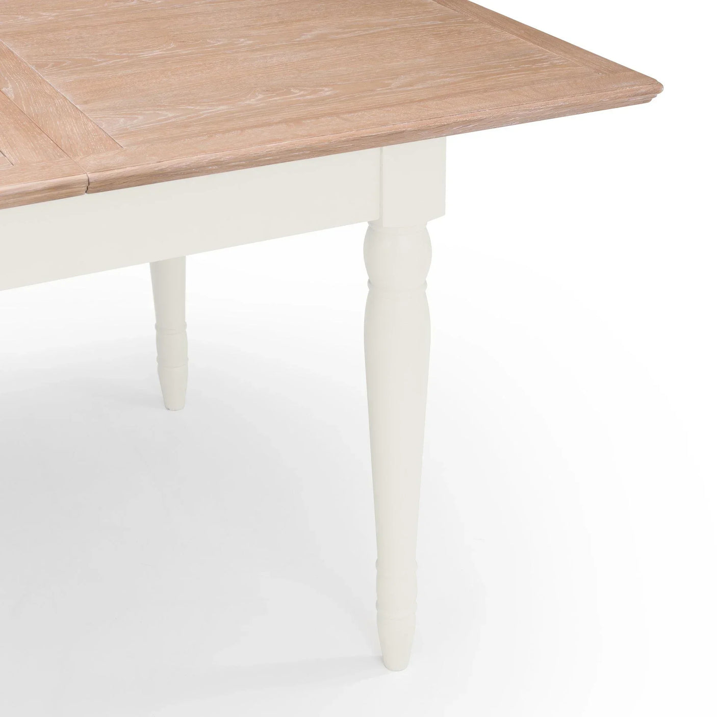 Oak dining table with white painted turned leg and wood grain top, corner angle view
