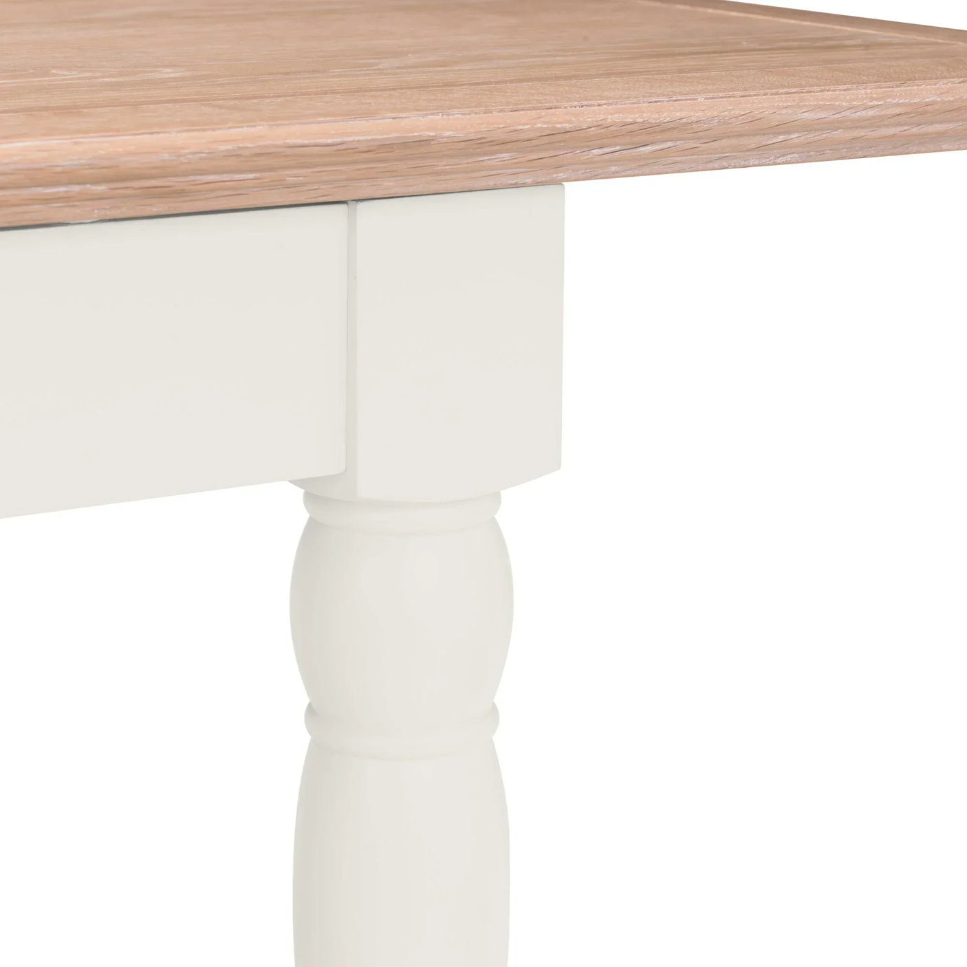Closeup of wooden dining table with light oak top and painted white turned leg