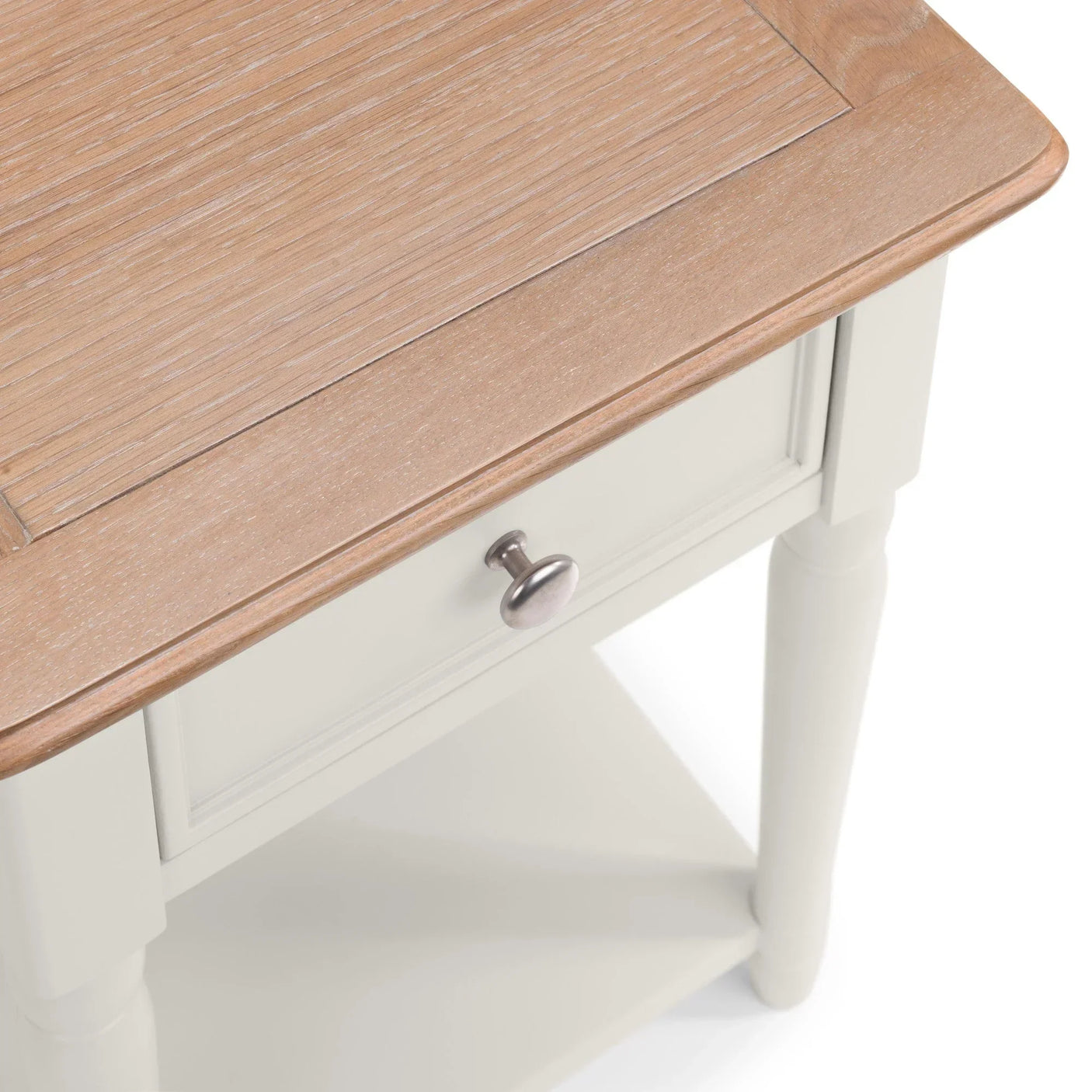 Oak top bedside table with white painted drawer and round brass knob, angled view