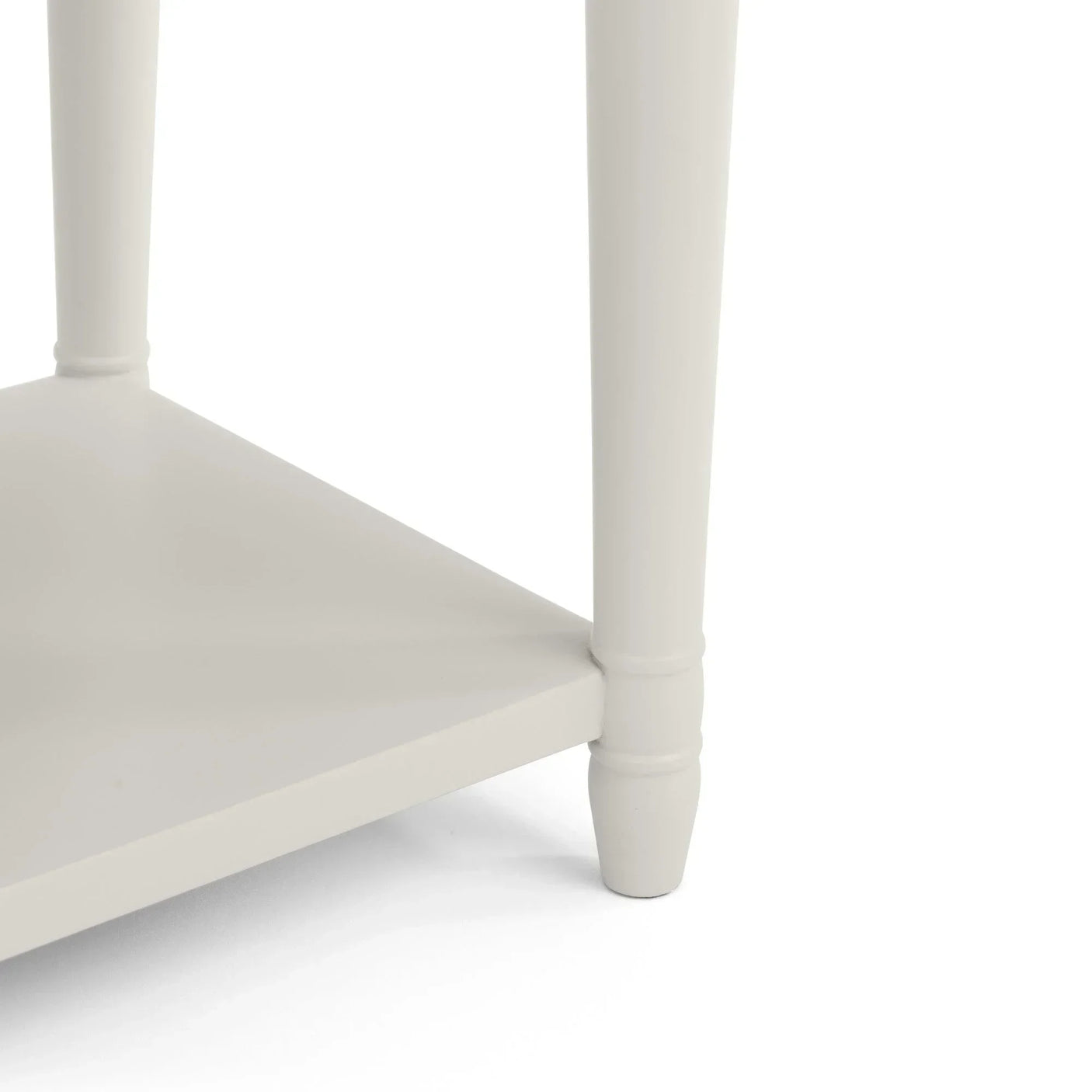 Close up of cream painted wooden table leg with lower shelf detail