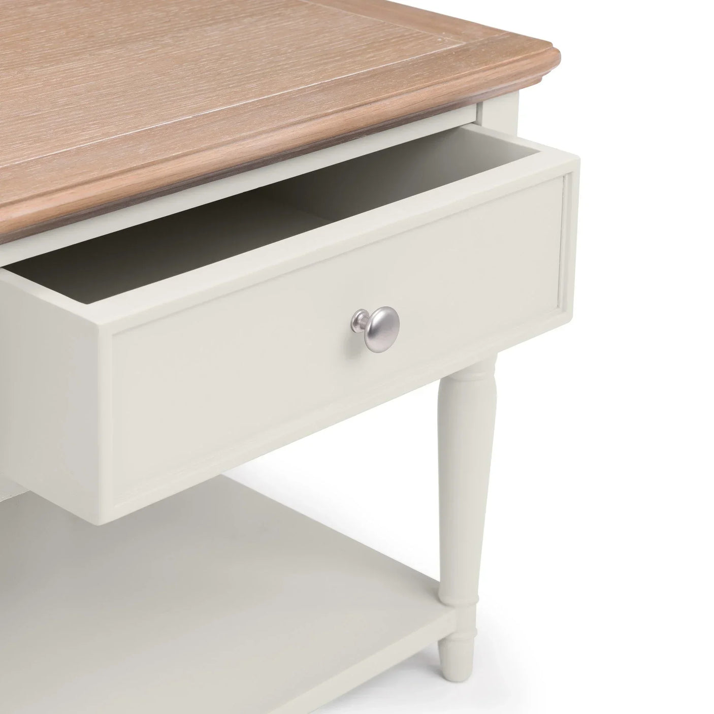 Cream wooden side table with drawer open and oak top, closeup on leg and handle