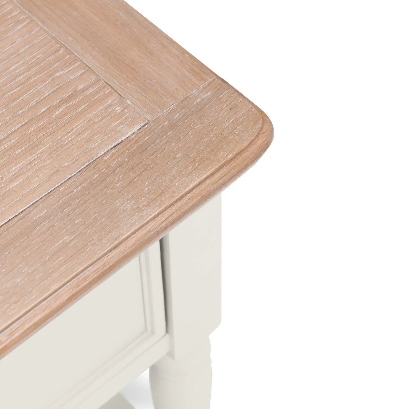Close-up of wooden table top with light oak finish and white painted corner detail