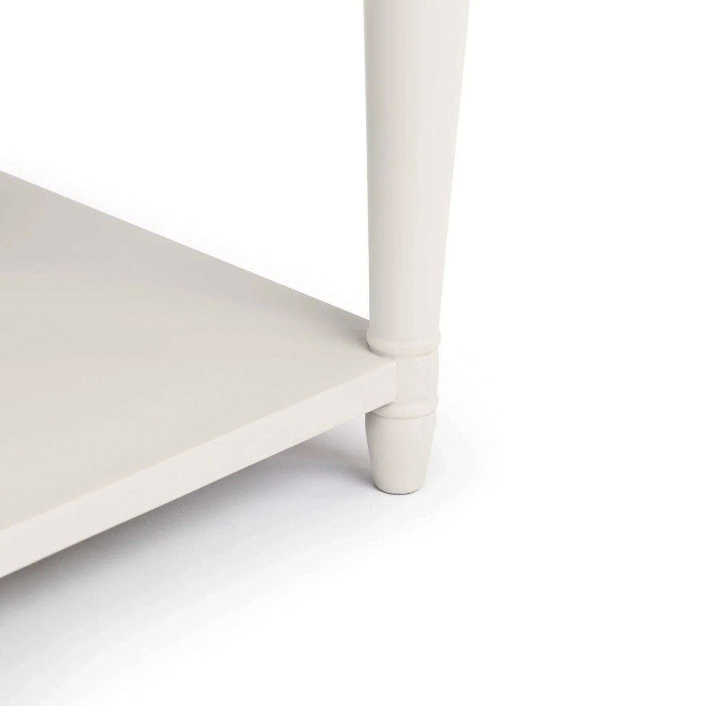 Close-up of cream painted wooden furniture leg and lower shelf corner
