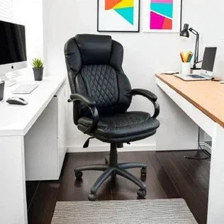 Black leather office chair with padded seat and armrests in modern home workspace