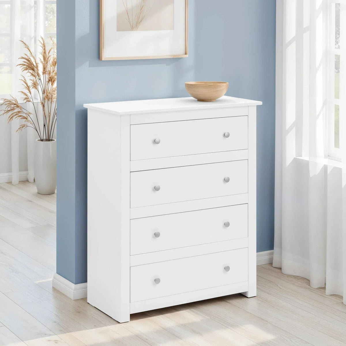 White four-drawer chest of drawers in a bedroom with a wooden bowl