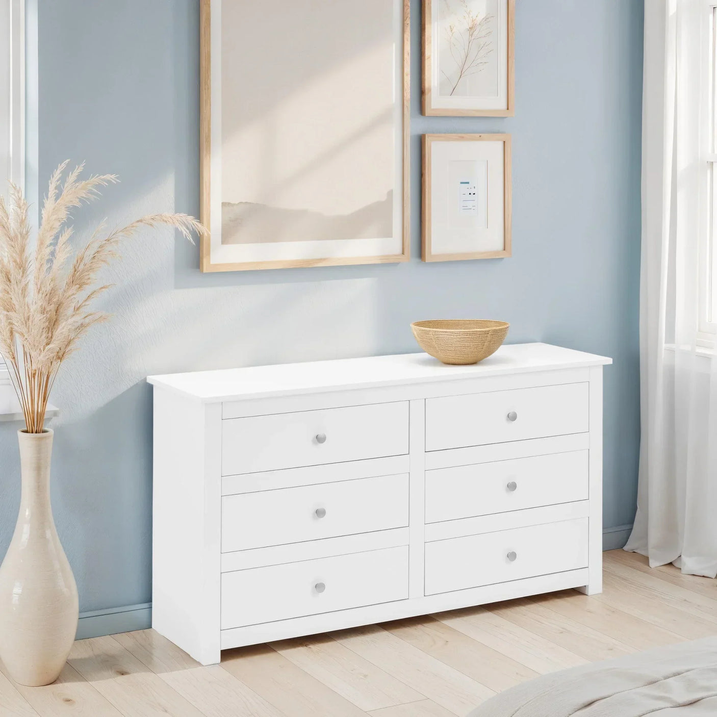 White wooden chest of drawers with six drawers in a modern bedroom setting