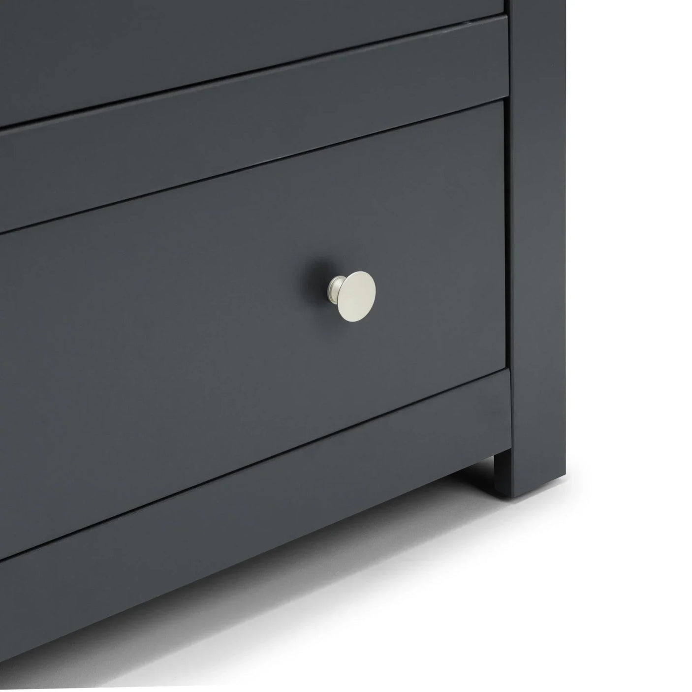 Closeup of dark grey chest of drawers with silver knob handle and smooth finish