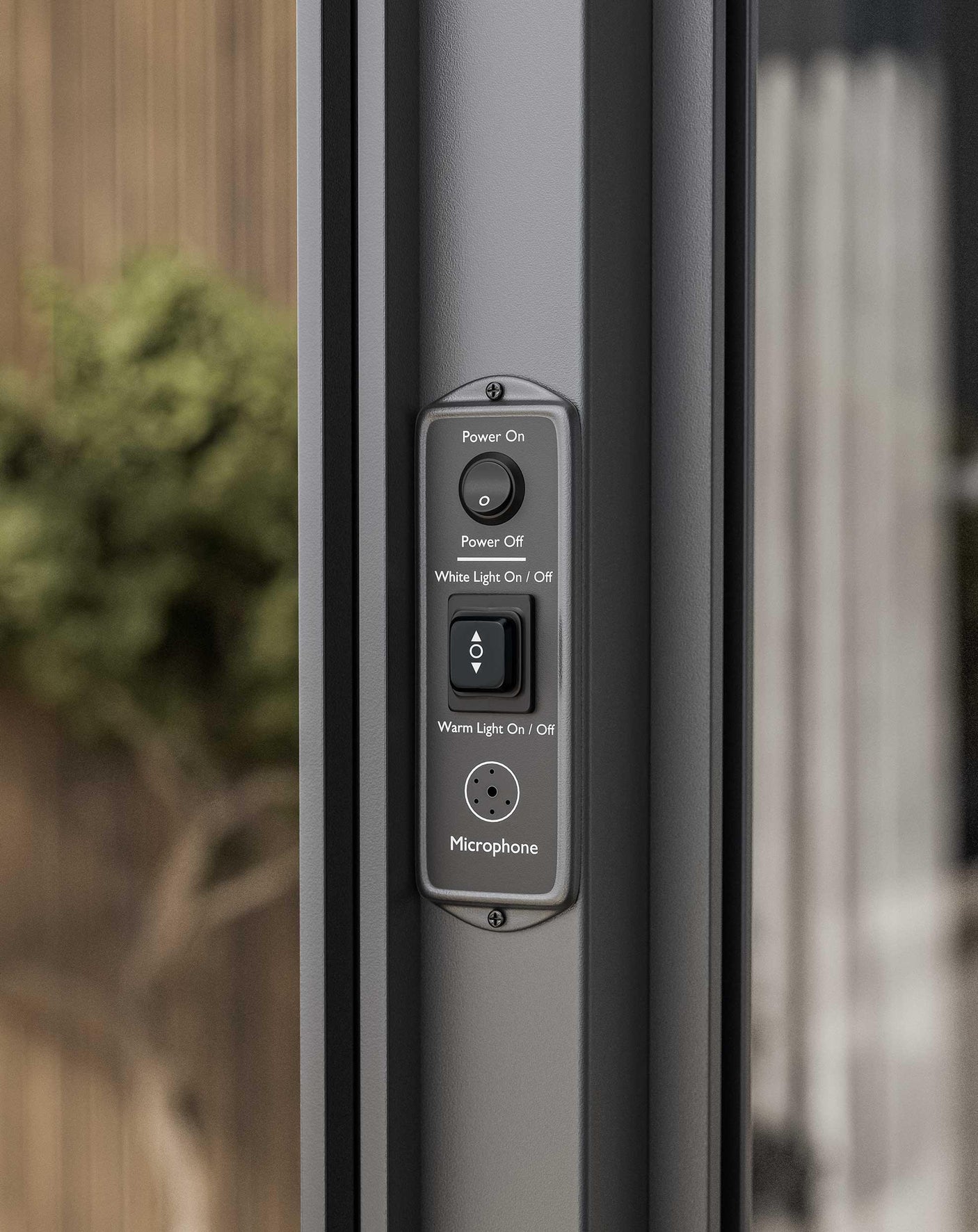 Close-up of smart patio door control panel with buttons for power, lighting, and microphone