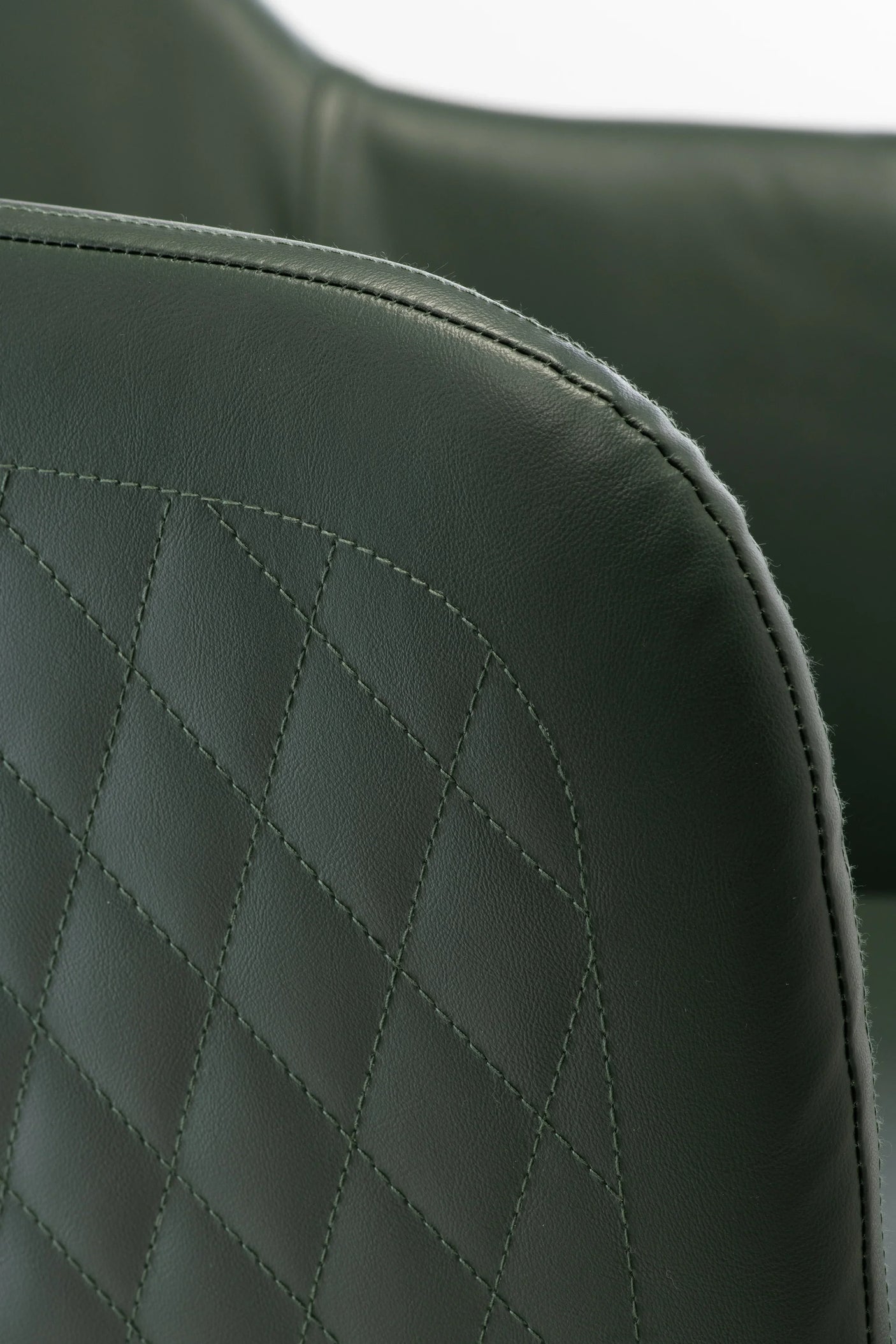 Close-up of green leather chair backrest with diamond stitching detail