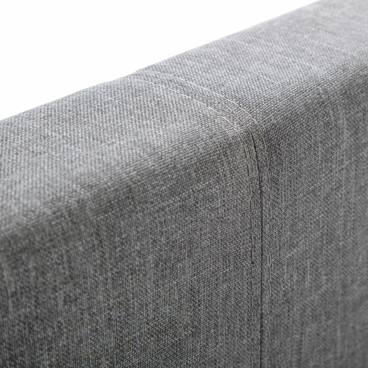 Grey fabric headboard corner with visible seam detail and textured upholstery