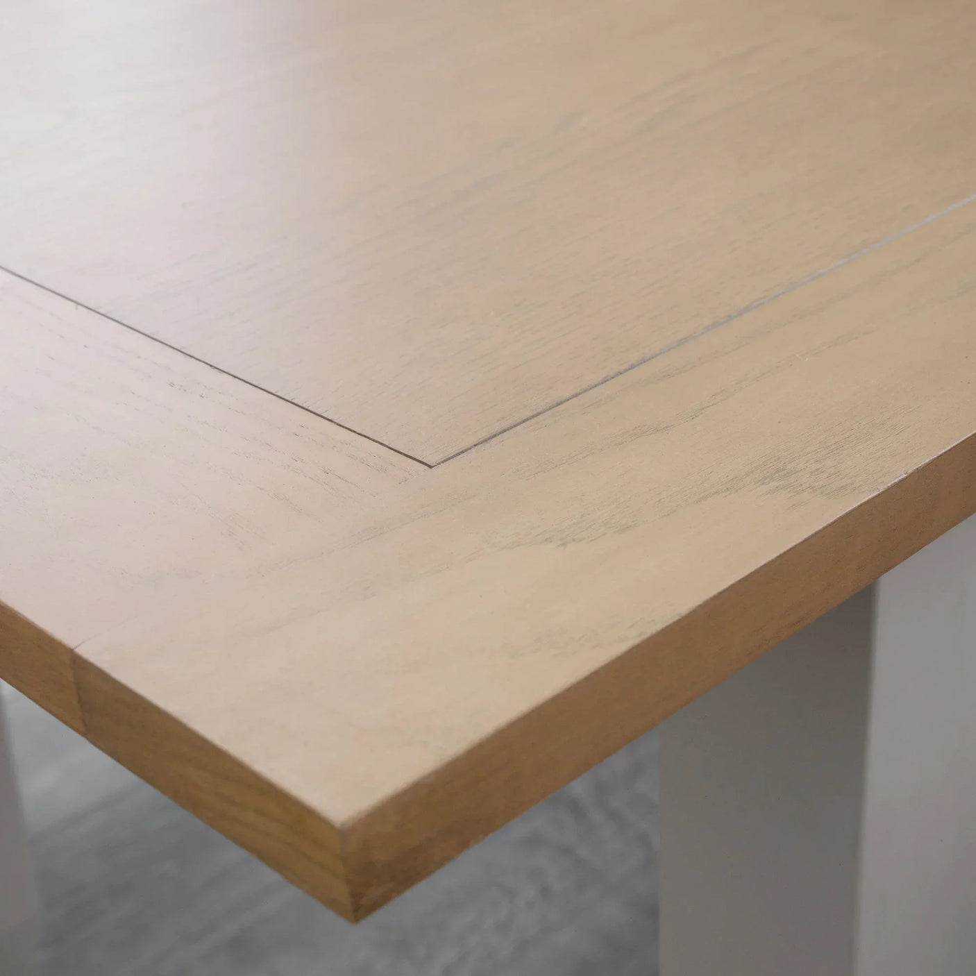 Light oak dining table corner showing wood grain and bevelled edge detail