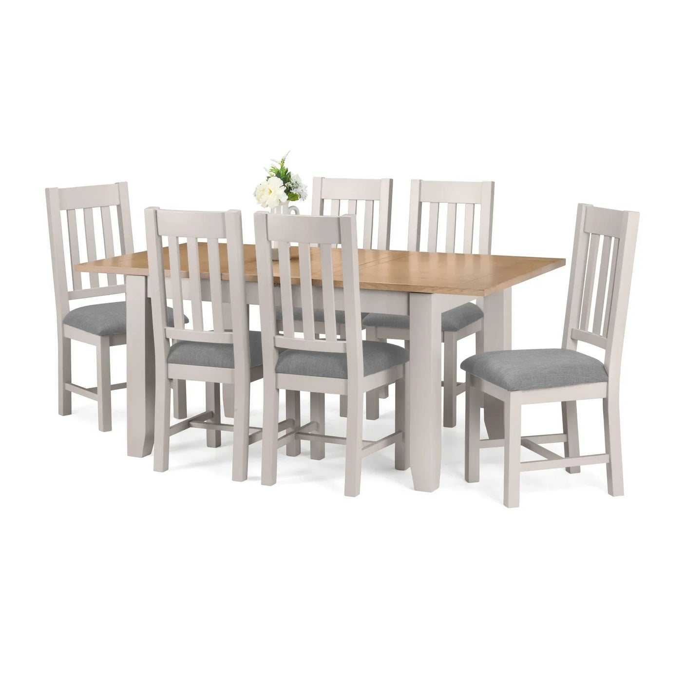 Rectangular oak dining table with six grey cushioned chairs and floral centrepiece