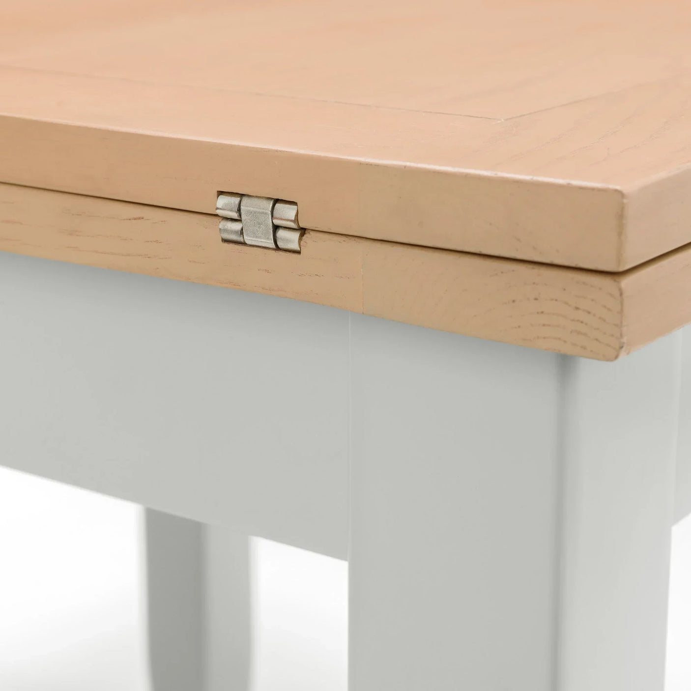 Light wood extending dining table with metal hinge detail on tabletop edge