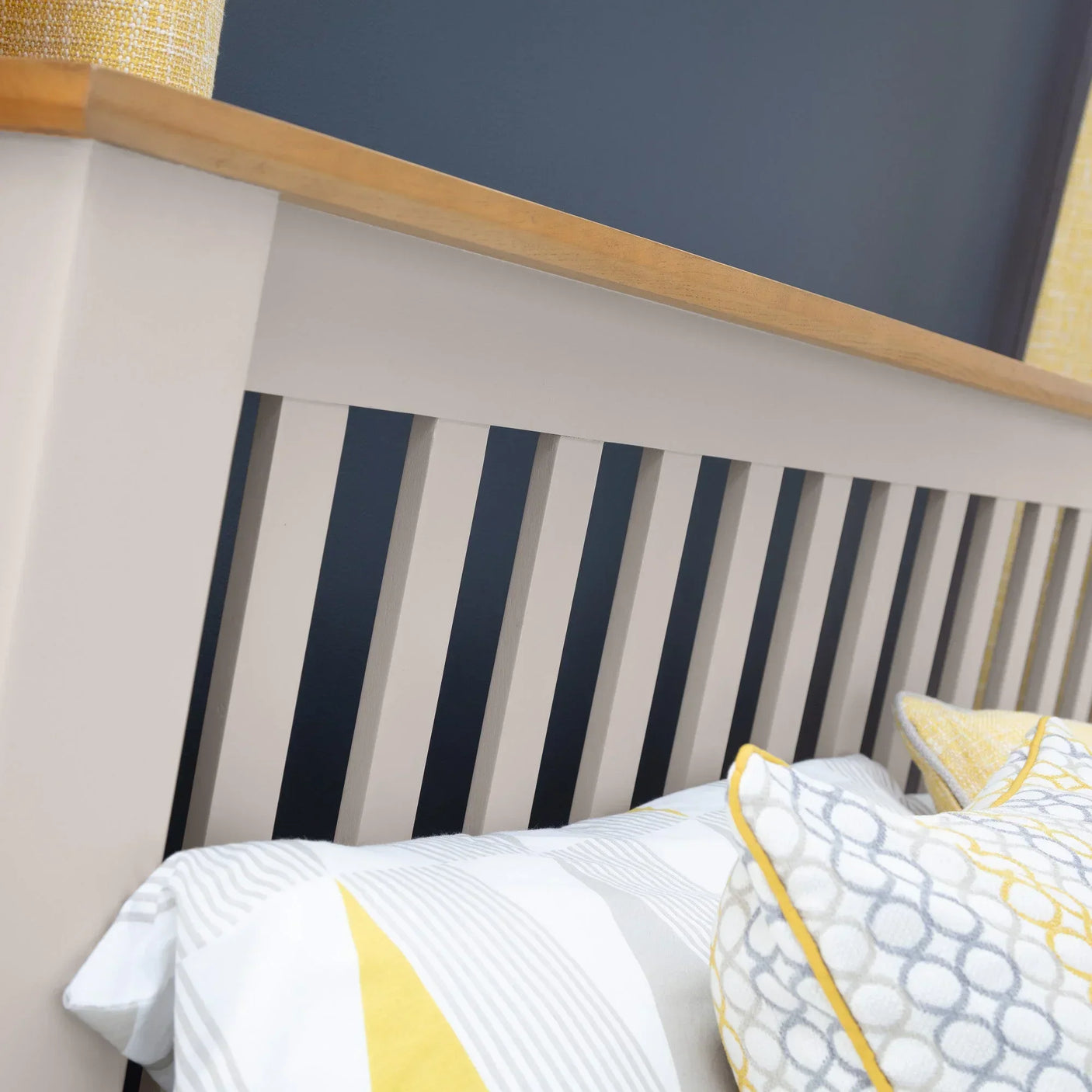 Wooden bed frame with slatted headboard detail and neutral bedding