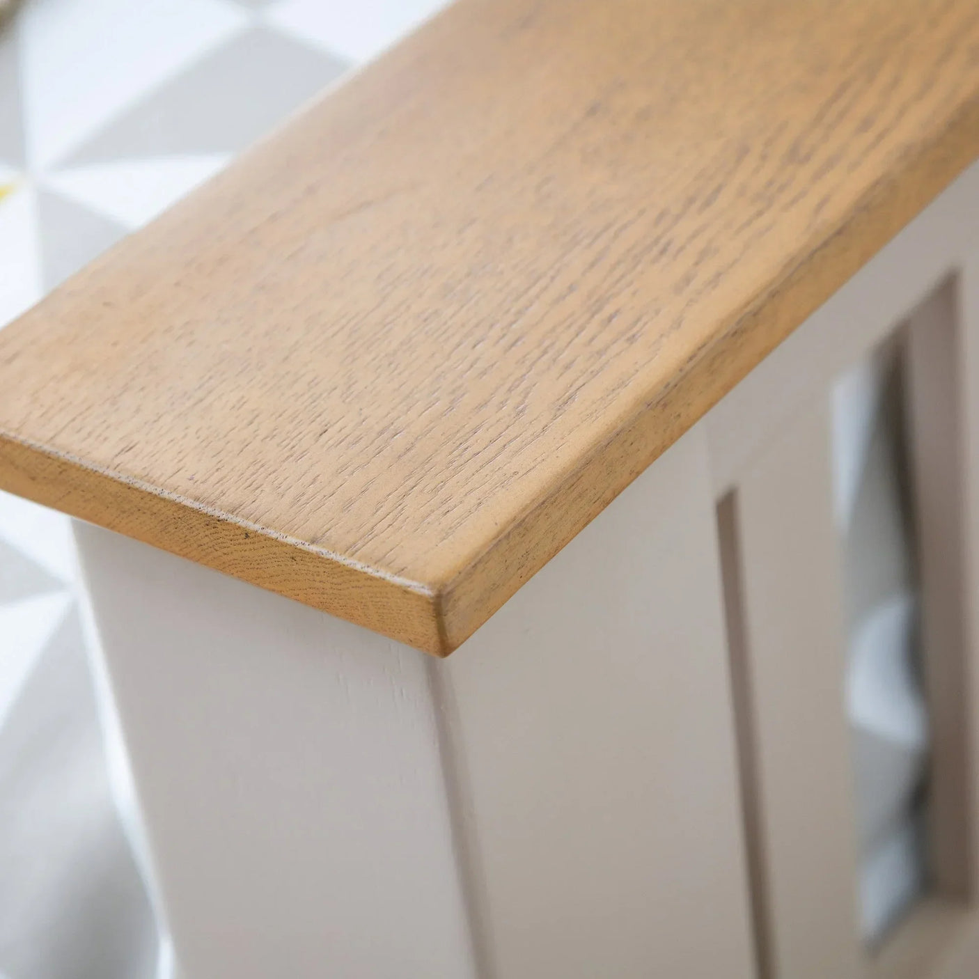 Close-up of wooden furniture top with light oak finish and panel detail
