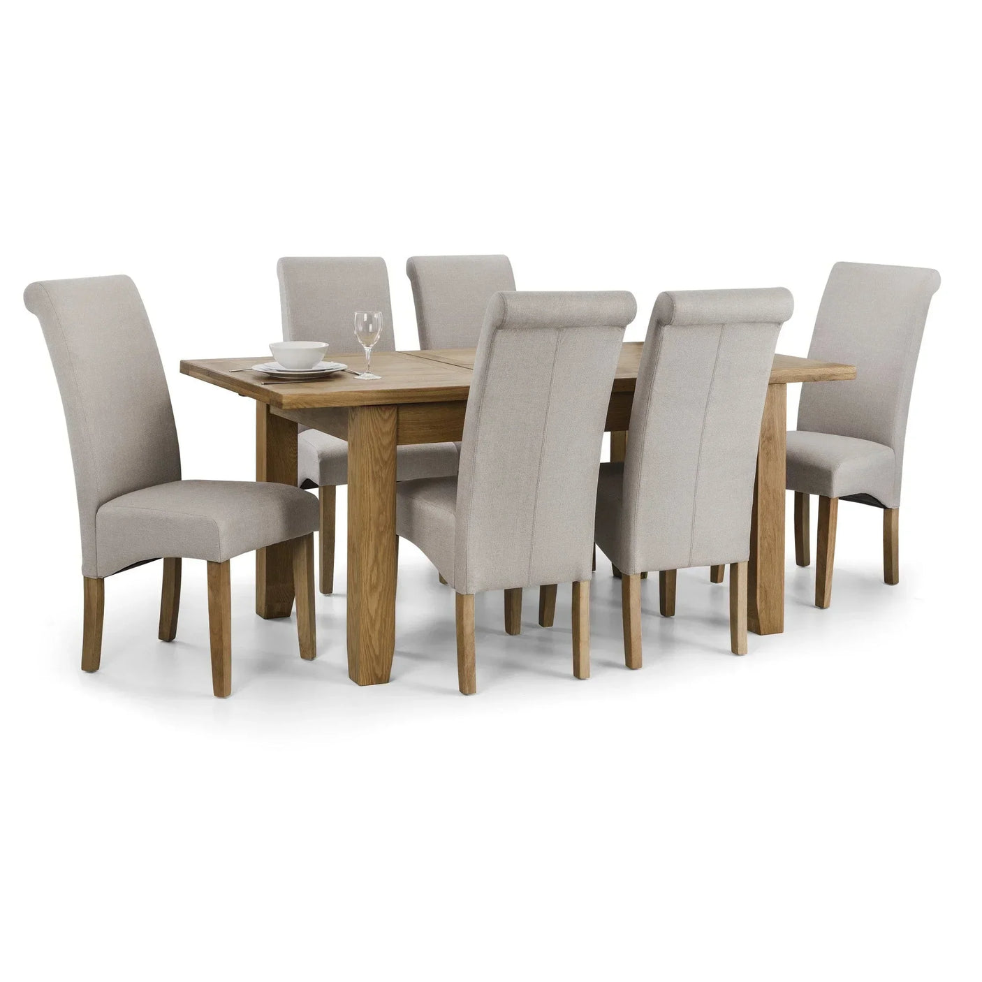 Oak dining table set with six beige upholstered chairs, tableware on the wooden surface