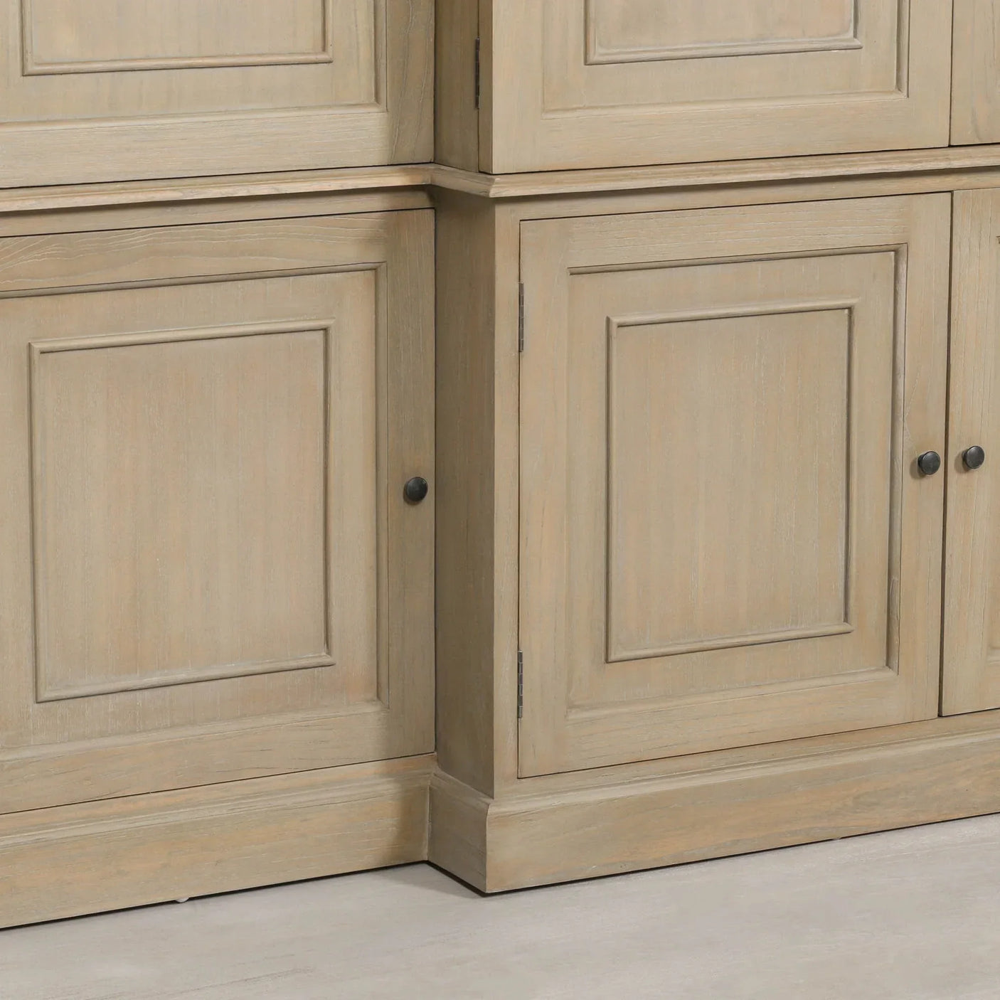 Close-up of wooden cabinet doors with panel detailing and black round handles