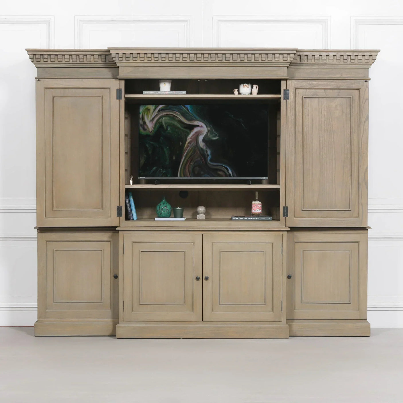 Wooden entertainment unit with storage cabinets and shelves featuring decorative molding