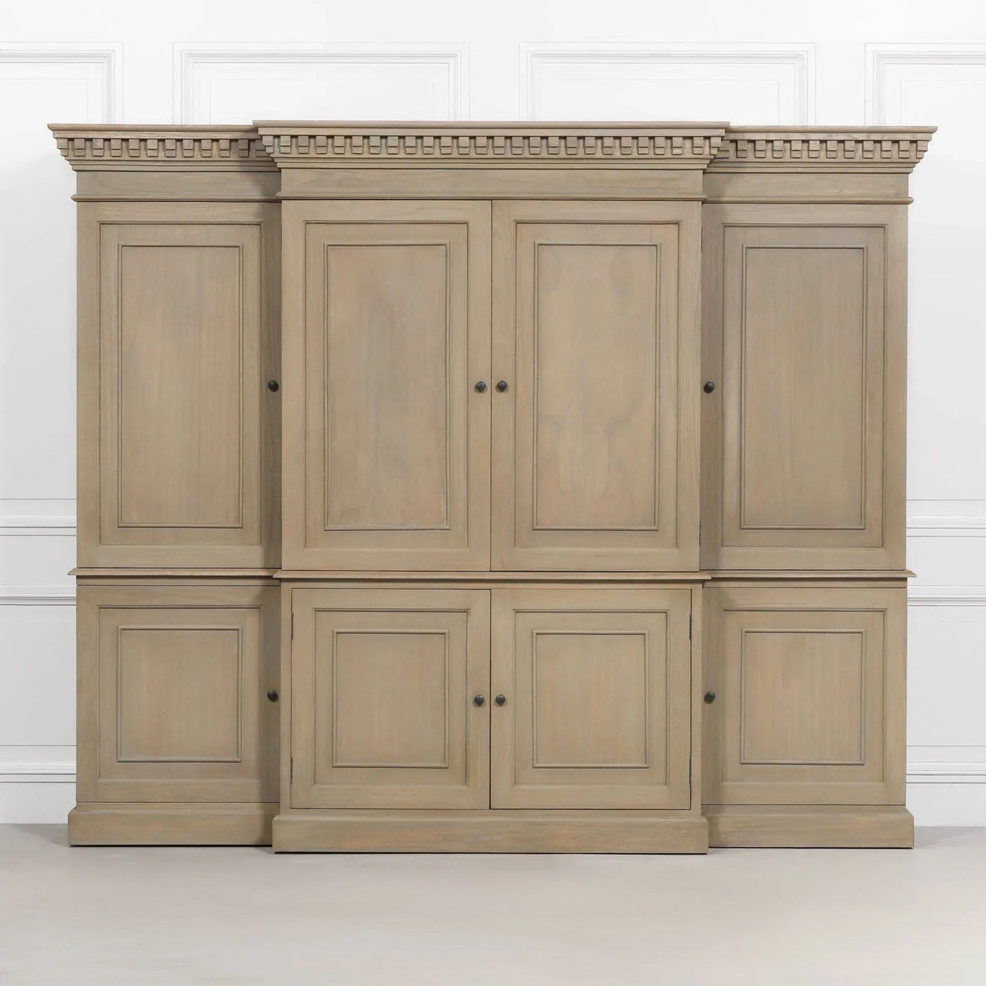Large wooden storage cabinet with six paneled doors and crown molding detail against a white wall