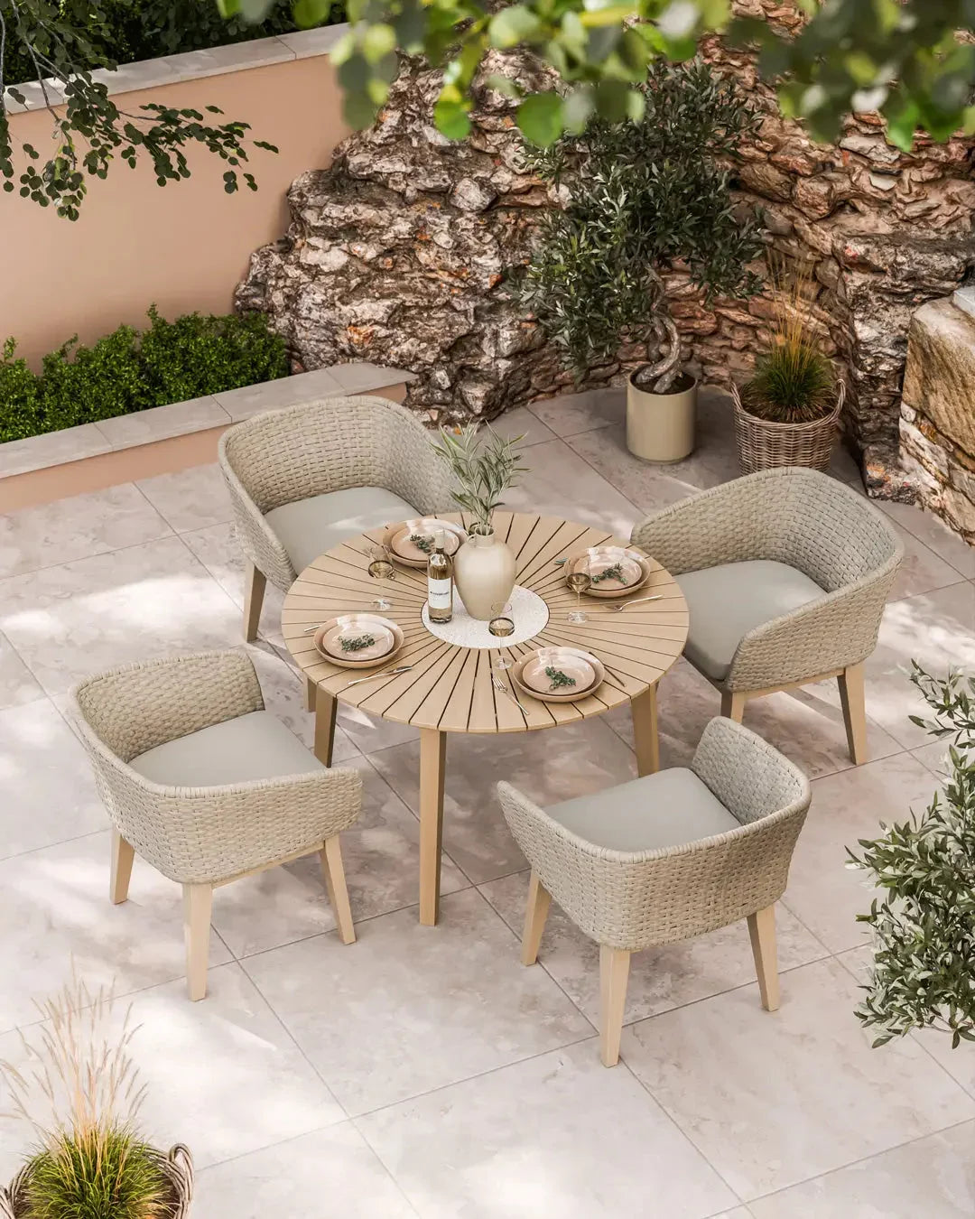 Beige rattan garden dining set with round wooden table and four cushioned chairs on patio